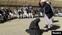 Një gjyqtar afgan duke e rrahur një grua para masës së njerëzve në provincën Ghor
