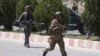 Afghan security personnel get into position at the site of an attack on the Interior Ministry in Kabul on May 30. 