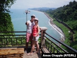 Tourists pose for a selfie in Batumi’s botanical gardens.