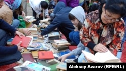 Кітап қарап отырған Алматы тұрғындары. 5 қыркүйек 2015 жыл. (Көрнекі сурет)