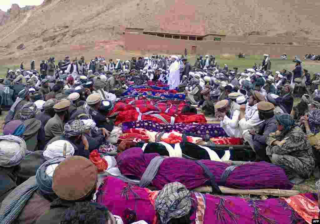 Miners sit next to the bodies of miners that died in a mine collapse.