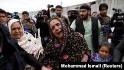 An Afghan Sikh woman mourns for her relatives near the site of an attack in Kabul on March 25.