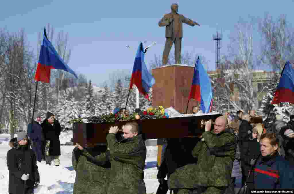 UKRAINE -- Men carry the coffin of one of the four fighters of the Luhansk separatist forces who were killed last week in fighting against Ukrainian government troops, during a funeral at a cemetery in the town of Kadiyivka, Luhansk Region, February 10,