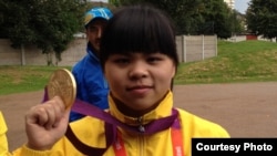 Қазақстандық ауыр атлет Зүлфия Чиншанло Лондон олимпиадасында алған алтын медальді көрсетіп тұр. Ұлыбритания, 29 шілде 2012 жыл.
