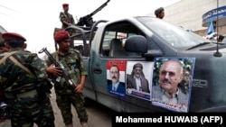 Yemeni security forces stand guard as Yemenis take part in a rally in support of Yemen's ex-president Ali Abdullah Saleh (portrait), as his political party marks 35 years since its founding, in the capital Sanaa. File photo. 