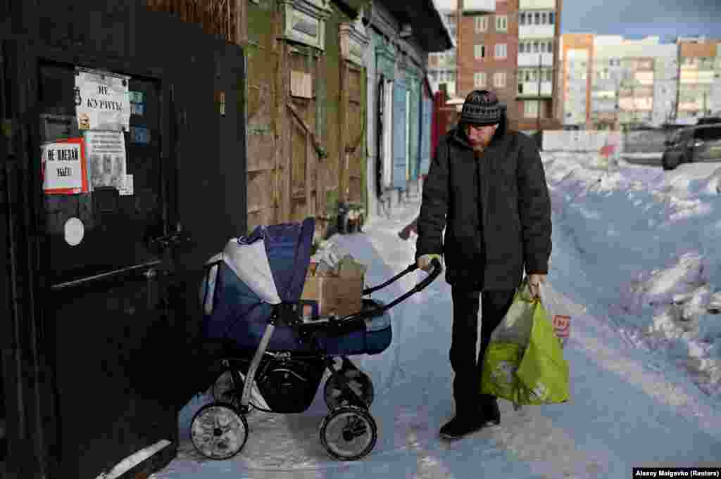 Denis, nicknamed Den &quot;Mladshy&quot; (Junior), pushes a pram that he uses to store and transport glass bottles and other recyclable items he can exchange for payment.