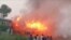 PAKISTAN - People watch fire burning a train after a gas canister passengers were using to cook breakfast exploded, near the town of Rahim Yar Khan in the south of Punjab province, Pakistan October 31, 2019
