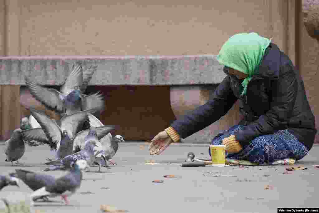 Жінка жебрак годує голубів на вулиці в центрі Києва, 3 жовтня 2017 року