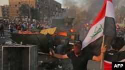 تظاهرکنندگان خشمگین در بغداد یک خودروی نیروهای امنیتی را به آتش کشیدند