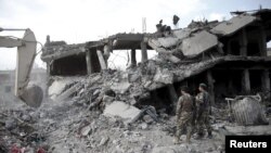 Afghan National Army soldiers watch as an excavator works at the site a truck bomb blast in Kabul on August 7. The attack in Kunduz took place the following day.