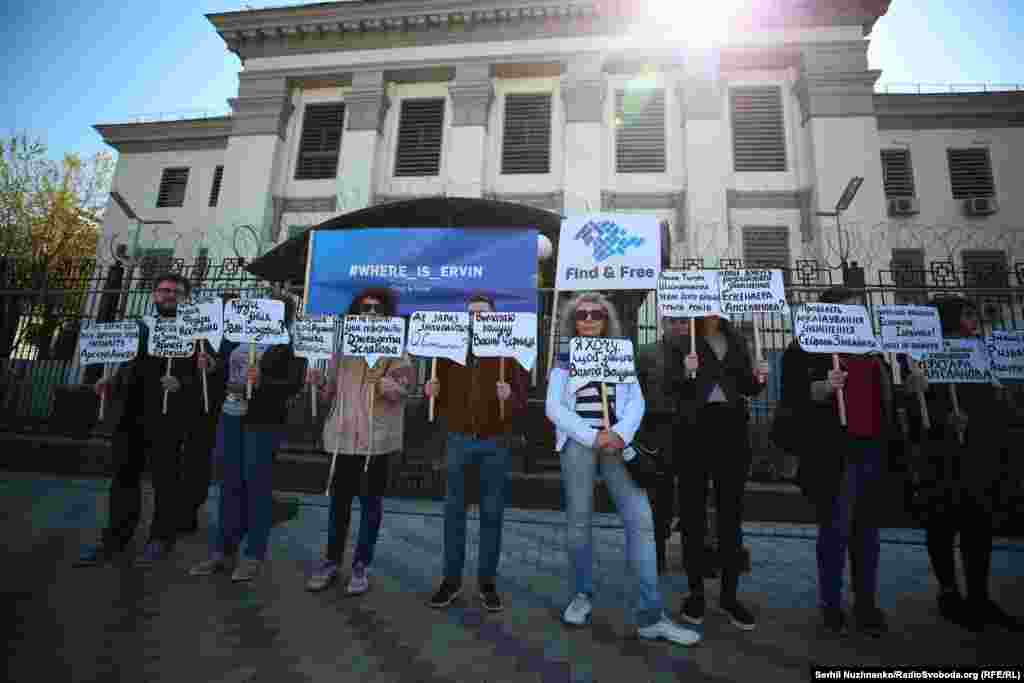 Активисты стоят с плакатами на фоне посольства России в Киеве