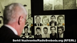 Олександр Зеленцов розглядає фотографії своїх колег. Його фото – у нижньому ряду крайнє праворуч