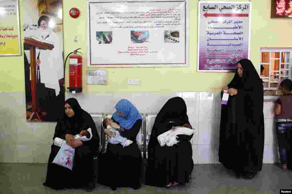 Women wait with their babies at a health clinic in Sadr City.
