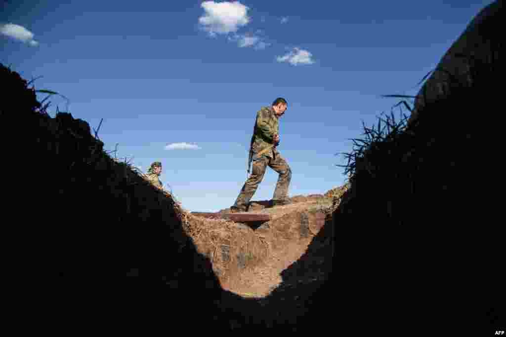 A Ukrainian serviceman walks past a trench on the front line near Luhansk during shelling on August 26. (AFP/Oleksandr Ratushniak)