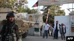 The staff director for Doctors Without Borders in Afghanistan, second right, MSF staff, and Afghan military personnel stand outside the entrance to the MSF hospital in Kunduz on October 15.