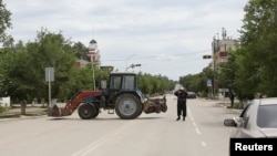 A Kazakh police officer blocks a street near the site of an exchange of fire between security forces and suspected militants linked to deadly attacks this week in Aqtobe. 