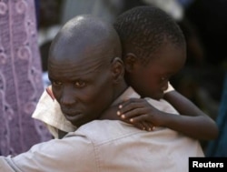 Мужчина и его сын, беженцы-динка, на территории миссии ООН в Джубе