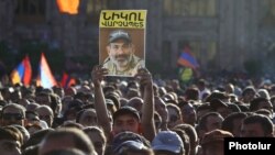 Участник митинга держит в руках портрет лидера протестного движения Никола Пашиняна, Ереван, 2 мая 2018 г