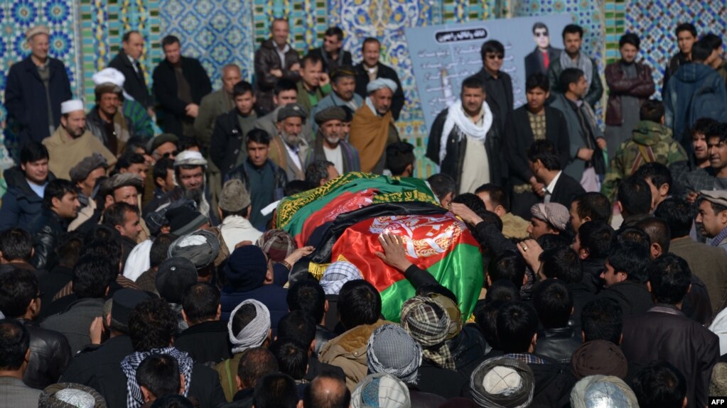 Afghan mourners carry the coffin of one of the six Afghan employees of the Red Cross in Mazar-e Sharif on February 9.