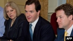 British Chancellor of the Exchequer George Osborne (center) addresses Deputy Prime Minister Nick Clegg (second from right) and other attendees of a cabinet meeting on October 20, ahead of the announcement of drastic spending cuts.