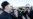 A Serbian Orthodox priest speaks with a riot policeman on a bridge near parliament, ahead of a vote on a bill on religious organizations in Podgorica on December 26.