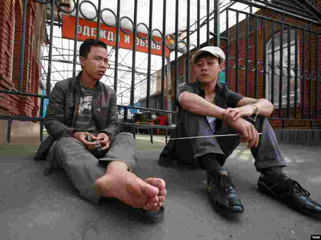 Russia -- Migrant workers who lost their jobs after the shutdown of the Cherkizov Market seen near the market gate, Moscow 12Jul2009 - Caption: ITAR-TASS 161: MOSCOW, RUSSIA. JULY 12, 2009. Migrant workers who lost their jobs after the shutdown of the Cherkizov Market seen near the market gate.