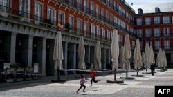 Copii jucându-se la Madrid, într-un oraș semipustiu