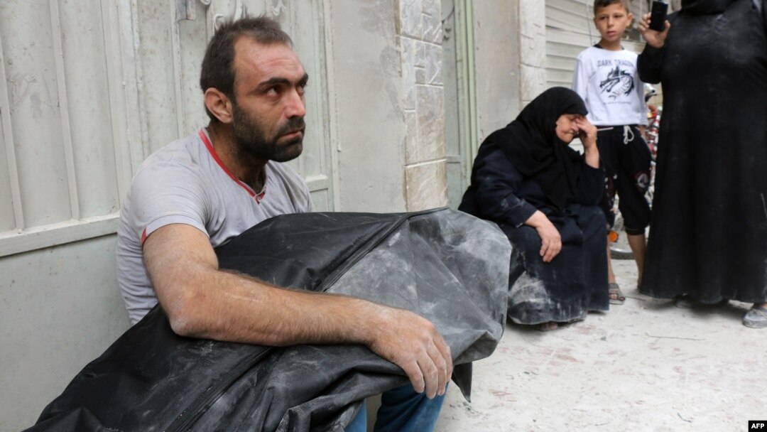 A Syrian man carries the body of his nephew following a reported air strike in Aleppo on September 23.