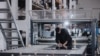 Muncitor într-o hală a unei companii producătoare de articole din inox destinate industriei alimentare și vinicole.