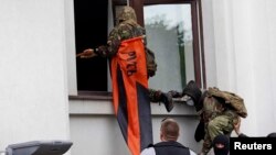 Pro-Russian activists attack the regional administration building in Luhansk on April 29.