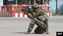 An Afghan National Army commando aims his weapon amid ongoing fighting between Taliban militants and Afghan security forces in the northern city of Kunduz.