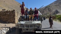 Taliban fighters sit atop a Humvee in the Omarz area of Panjshir Province in September 2021.