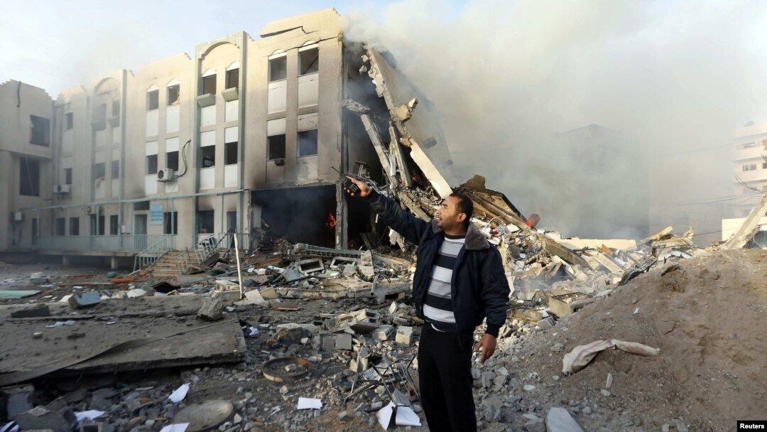 A member of Hamas security forces points to an unexploded missile (not seen) after an Israeli air strike on the building of the Hamas Interior Ministry in Gaza City.
