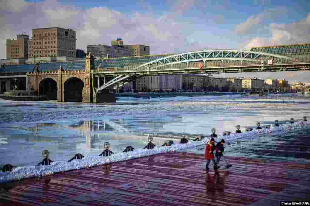 Two young women dance on an embankment of the Moskva River in Moscow. (AFP/Dimatar Dilkoff)