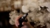 A man holds an electronic cigarette as he vapes at a Vape Shop in Monterrey