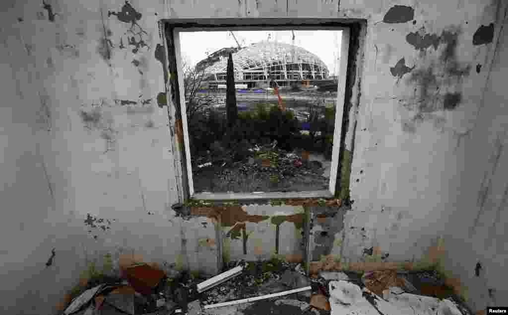 A look through the window of a house that has to be torn down as it is within the perimeters of the Olympic Park shows the stadium for the Sochi 2014 Winter Olympics at Olympic Park in Adler, near Sochi, Russia. (Reuters/Kai Pfaffenbach)