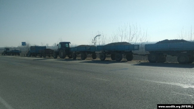 Груженные навозом тракторы стоят на трассе при въезде из Джизака в Самаркандскую область, 11 января 2021 года.