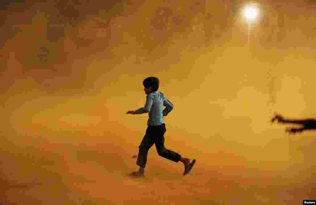 A boy runs for cover during a dust storm in New Delhi. (Reuters/Adnan Abidi)