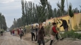 CHINA -- People work on a street in a small village where ethnic Uighurs live on the outskirts of Shayar in the region of Xinjiang, September 13, 2019