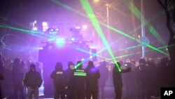 პროევროპულ აქციაზე დემონსტრანტები პოლიციას ლაზერით ანათებენ.