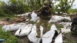 UKRAINE – A Ukrainian serviceman works during the exhumation of killed Russian soldiers' at their former positions near the village of Malaya Rohan, on the outskirts of Kharkiv, May 18, 2022