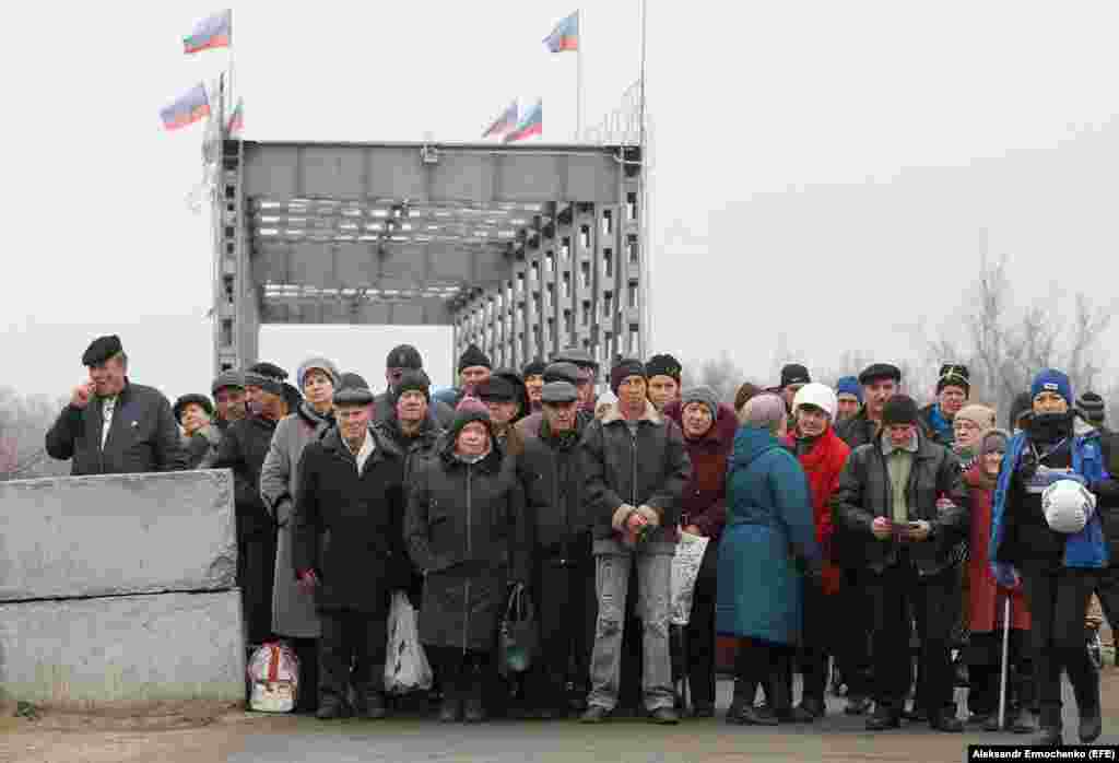 Люди з непідконтрольної Україні території чекають на дозвіл перейти реставровану пішохідну частину мосту у селищі Станиця Луганська, 20 листопада 2019 року