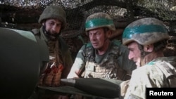 Ukrainian servicemen fire a self-propelled howitzer toward Russian troops near the front-line town of Pokrovsk