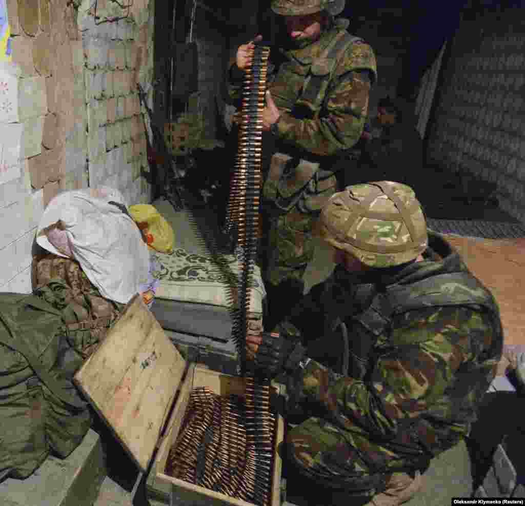 Ukrainian fighters unload belts of bullets from a crate in 2015. Wooden ammunition boxes also are used throughout eastern Ukraine to transport rockets, grenades, and artillery shells.