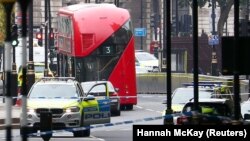 Британ парламенті ғимаратының қоршауына соқтыққан көлікті полицейлер көліктері қоршап тұр. Лондон, 14 тамыз 2018 жыл.