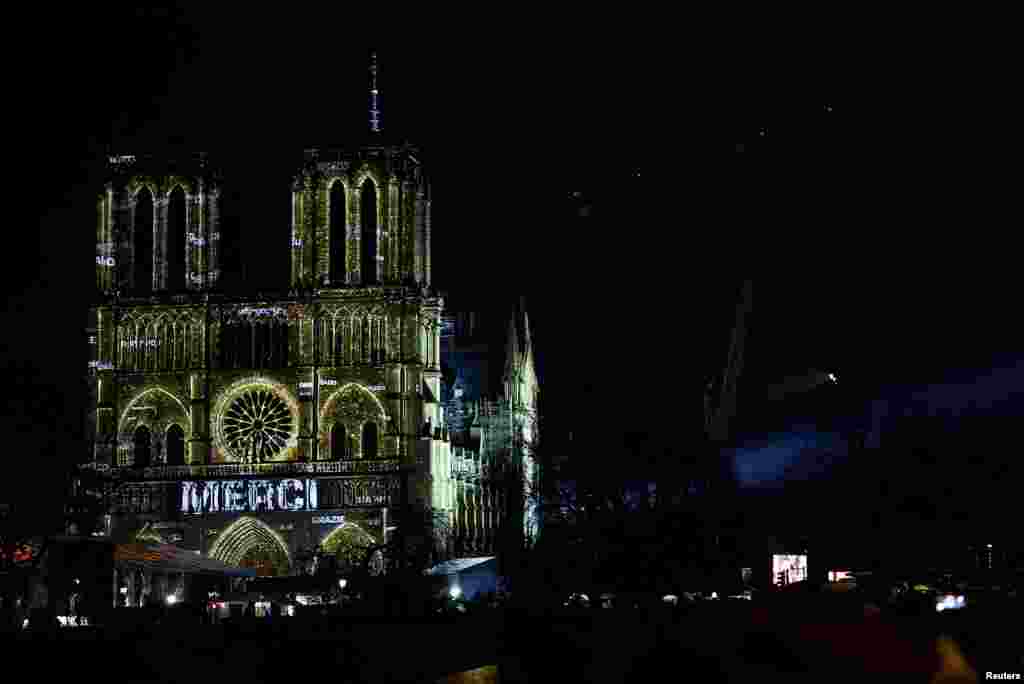 Fjala &quot;faleminderit&quot; e ndriçuar në fasadën e katedralen Notre Dame në nisjen e ceremonisë së rihapjes të ndërtesës. &nbsp; 