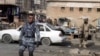 Iraqi security officers guard the scene of roadside bombing in Baghdad earlier this year