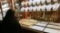 An Iranian woman looks at the window of a jewellery shop at the Bazaar of Tabriz in East-Azerbaijan province northwestern Iran, 17 May 2007.(Photo by BEHROUZ MEHRI / AFP)