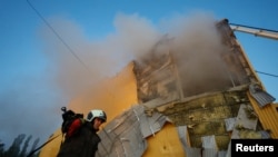 Пожарный у поврежденного обломками дрона предприятия, Киев, 28 мая 2023 года