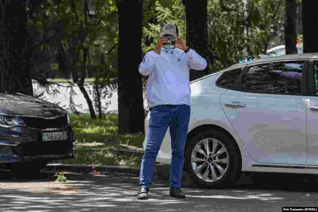 Сотрудник силовых органов снимает журналистов на смартфон.&nbsp;Алматы, 17 июля 2021 года